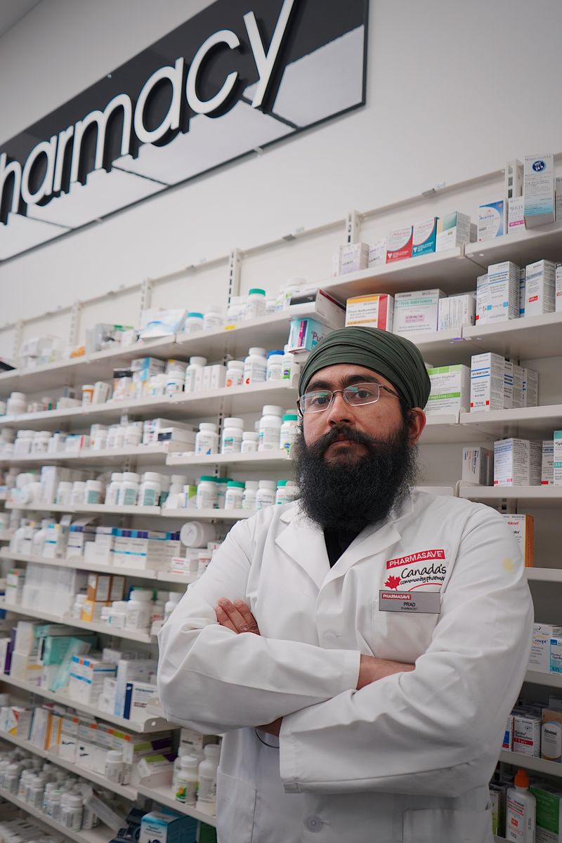 Pharmacist standing in front of stocked pharmacy shelves